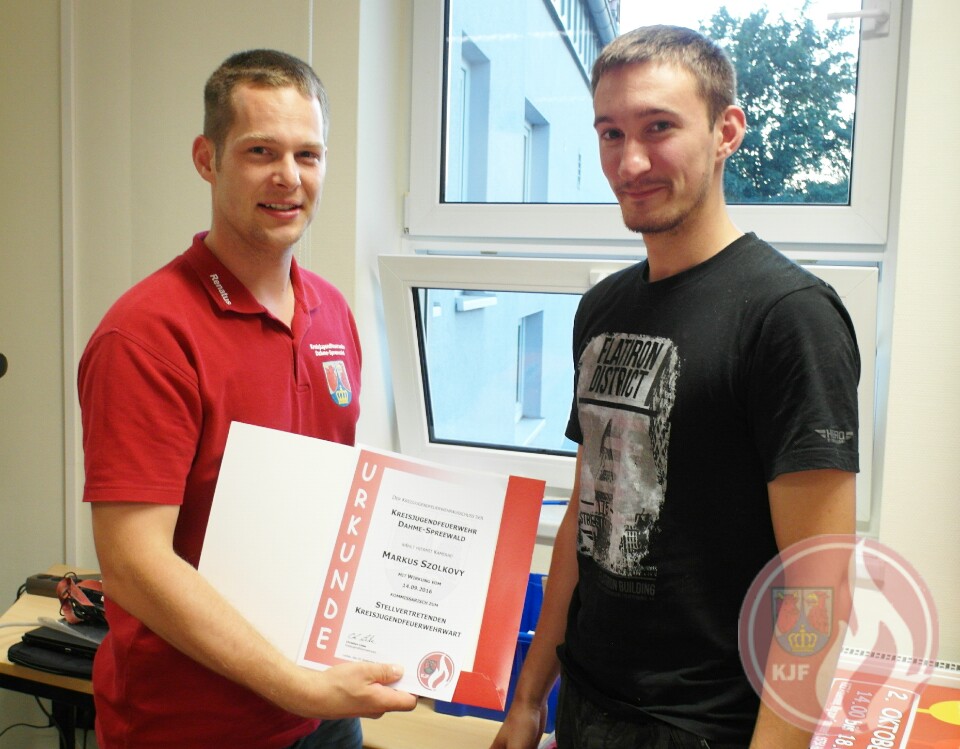 Stellvertretender Kreisjugendfeuerwehrwart Renatus Welzel (li.) überreicht die Urkunde an Markus Szolkovy (re.)